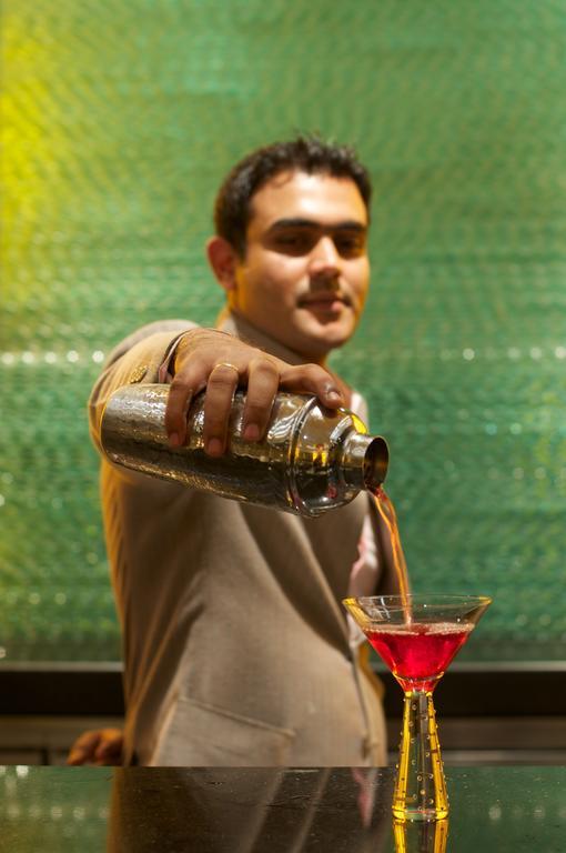 Vivanta Hyderabad, Begumpet Bagian luar foto A bartender pouring a drink